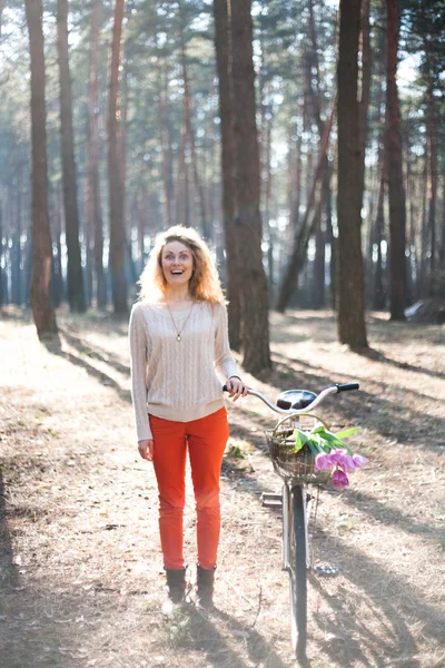 日当たりの良い公園で自転車上で美しい若い女性 — ストック写真