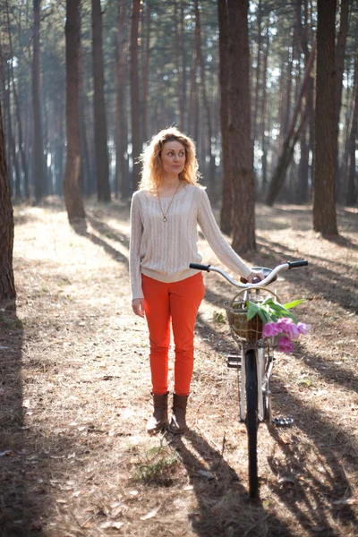 Красивая молодая женщина на велосипеде в солнечном парке — стоковое фото