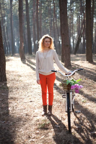 日当たりの良い公園で自転車上で美しい若い女性 — ストック写真