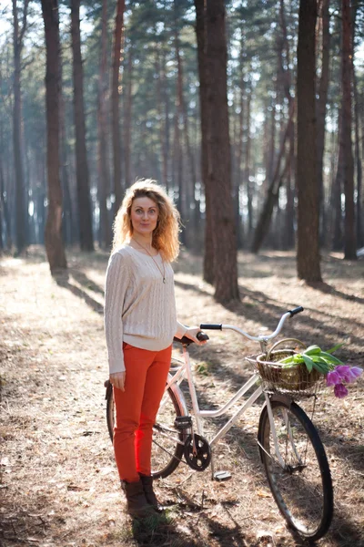 日当たりの良い公園で自転車上で美しい若い女性 — ストック写真