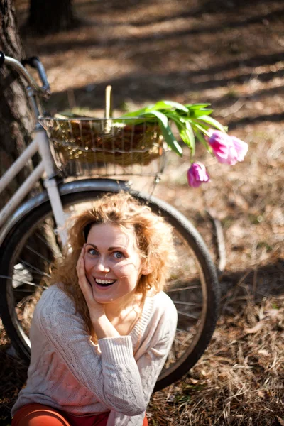 Beautiful young woman on bike in sunny park — Stock Photo, Image