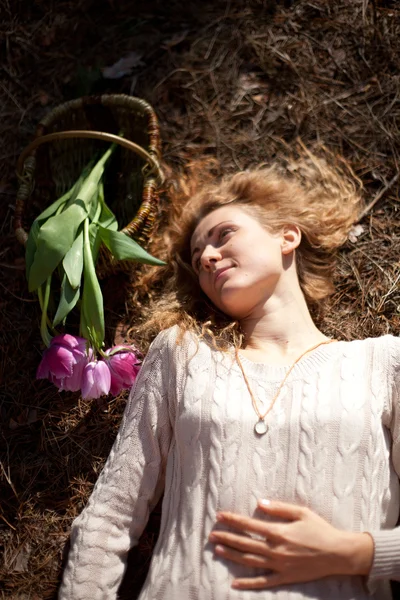 Gyönyörű lány, pihen, fekszik a fűben, a lila tulipán — Stock Fotó