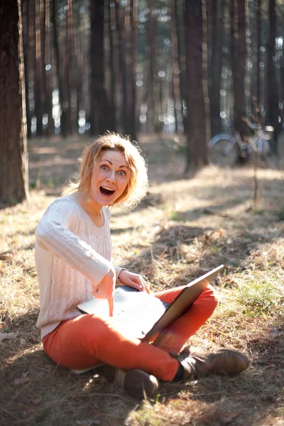 Smilende ung pige med laptop udendørs - Stock-foto