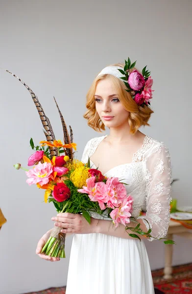 Mariée avec un bouquet lumineux et des fleurs dans ses cheveux — Photo