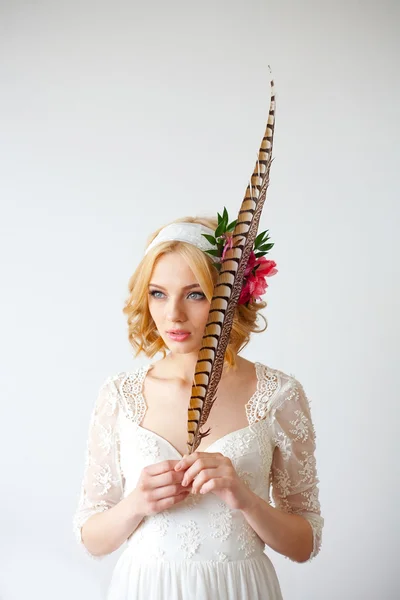 Beautiful bride posing with long feather — Stock Photo, Image