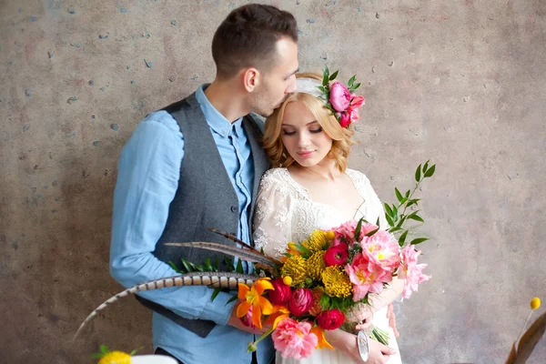 Ungt bryllup par mod tekstur væg - Stock-foto