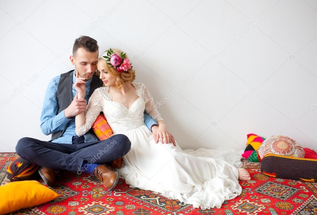barefooted bride and groom sitting on floor