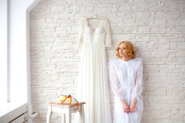 Güzel sarışın gelin yakınındaki beyaz tuğla duvar