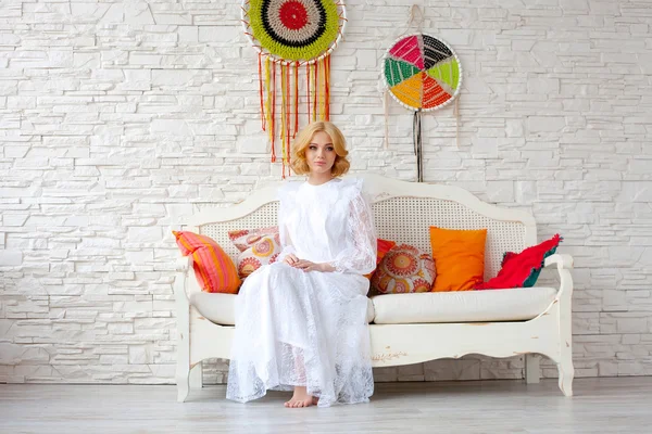 Woman sitting on white sofa — Stock Photo, Image