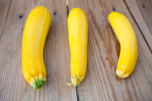 Yellow zucchini on wooden background, top view — ストック写真