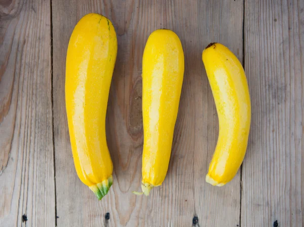 Yellow zucchini on wooden background, top view — Zdjęcie stockowe