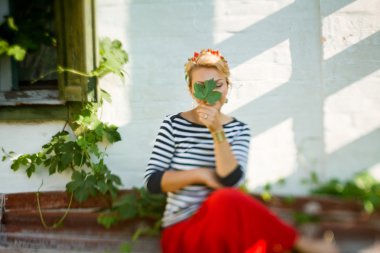 Beautiful girl sitting on bench near rural house