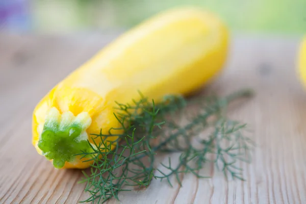 Yellow zucchini and dill on wooden background — ストック写真