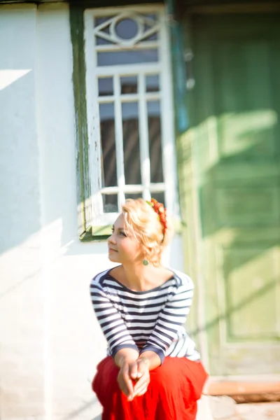 Schönes Mädchen sitzt auf den Stufen des ländlichen Hauses — Stockfoto