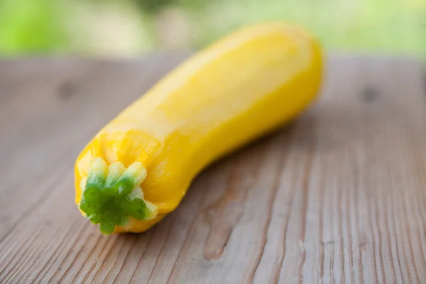 Yellow zucchini on wooden background, close up — ストック写真