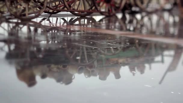 Detail of puddle with reflection of cart of clay pots and  falling raindrops — Stock Video