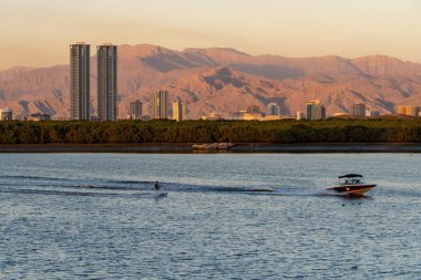 Ras al Khaimah, Birleşik Arap Emirlikleri Corniche Spor teknelerine ve gün batımında Hajar Dağlarına ve Kulelerine.