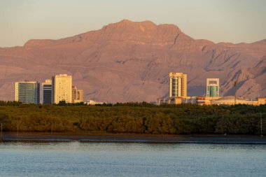 Ras al Khaimah, Birleşik Arap Emirlikleri RAK AVM manzaralı Hajar Dağları ve Daire Kuleleri gün batımında.