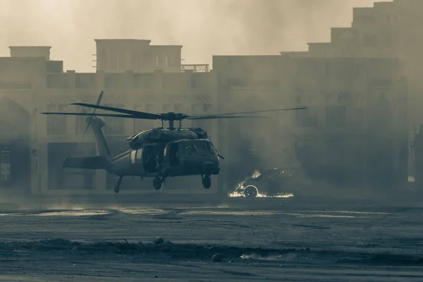 Military combat and war with helicopter landing in the chaos and destruction. Smoke and fire on the ground. Military concept of power, force, strength, air raid.