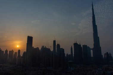 8 / 11 / 2020 - Dubai, Birleşik Arap Emirlikleri: Burj Halife ve Dubai Skyline 'ın günbatımında güneş ve Orta Doğu' daki mavi gökdelenlerle birlikte diğer gökdelenlerle birlikte ikonik manzara