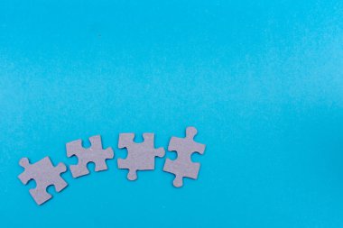 Puzzle parçaları açık mavi düz zemin üzerinde bağlanmak üzere takım çalışması, birlik, iş, hayat ve eğitim kavramları için yatıyordu.