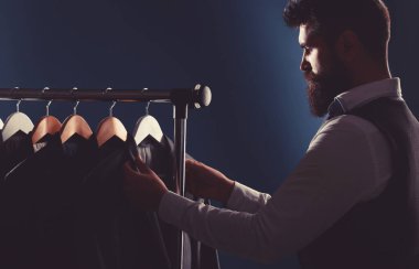 Terzi, terzilik. Erkek kıyafeti, atölyesinde terzi. Zarif adamlar peş peşe asılıyor. Lüks erkekler klasik takım elbiseli şık erkekler.