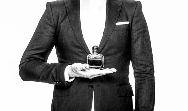 Perfume or cologne bottle and perfumery, cosmetics, scent cologne bottle, male holding cologne. an in a suit holding a bottle of perfume isolated on white background. Black and white — Stock Photo, Image