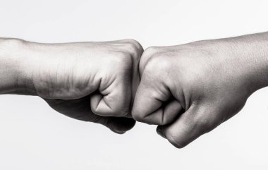 İnsanlar yumruklarını birbirine vuruyor, kollarını. Adam yumruk tokuşturuyor. Takım konsepti. Erkeklerin elleri yumruk tokuşturma takım çalışması, başarı. Dostça tokalaşma, dostça selamlaşma. Siyah ve beyaz