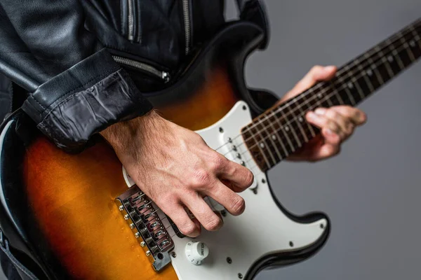 Man playing guitar. Close up hand playing guitar. Musician playing guitar, live music. Electric guitar. Repetition of rock music band. Music festival