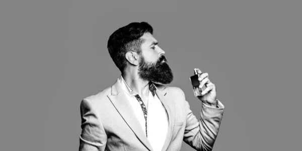 Bouteille de parfum ou d'eau de Cologne et parfumerie, cosmétiques, bouteille de parfum d'eau de Cologne, mâle tenant de l'eau de Cologne. parfum masculin, homme barbu en costume. noir et blanc — Photo