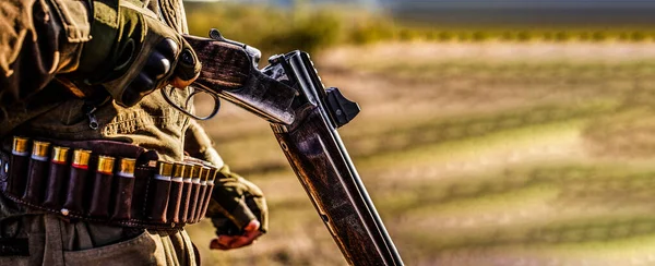 Un chasseur. Période de chasse, saison d'automne. Un homme armé. Un chasseur avec un fusil de chasse et une forme de chasse pour chasser dans une forêt d'automne. L'homme est à la chasse. Chasseur avec un sac à dos et un pistolet de chasse — Photo