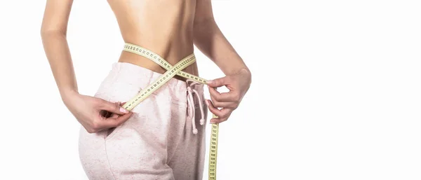 Slim girl with centimeter. Closeup woman measuring her waist with tape. Slim womans body. Woman with measuring tape. Weight loss concept. Woman take waist scale tape show her thin waist — Stock Photo, Image
