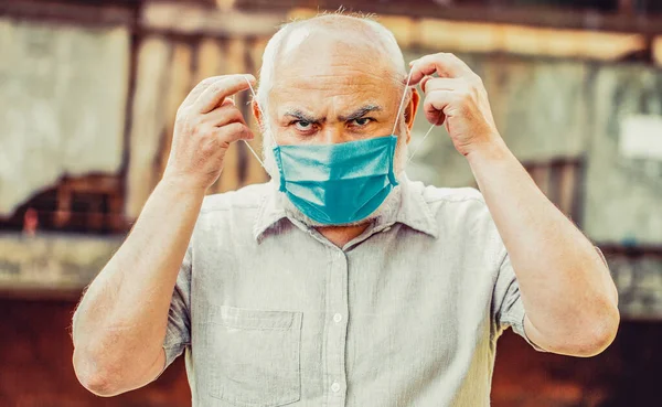 Old man wearing face mask. Portrait of an old man, years old, in a medical mask