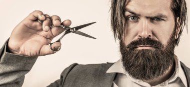 Berber makası. Sakallı adam gri arka planda izole edilmiş. Berber dükkanında erkek tıraşı. Berber makası, berber dükkanı.