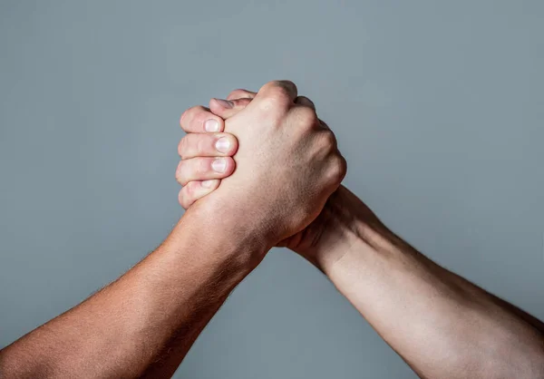 Man hand. Two men arm wrestling. Arms wrestling. Closep up. Friendly handshake, friends greeting, teamwork, friendship. Handshake, arms, friendship. Hand, rivalry, vs, challenge, strength comparison