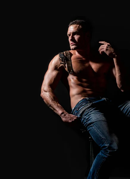 Muscular torso and chest. Muscular torso close up. Torso six packs attractive. Leather belt, jeans. Torso six packs looks attractive on black background. Muscular model sports man on dark background — Fotografia de Stock