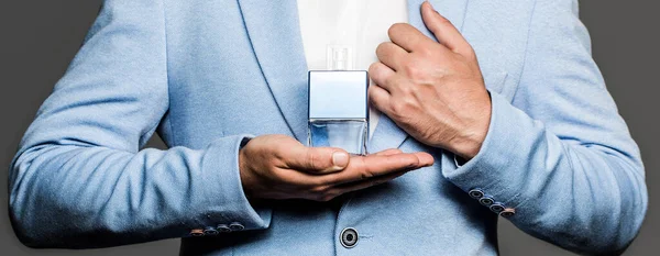 Perfume or cologne bottle and perfumery, scent cologne bottle. Male holding up bottle of perfume in suit. Man holding up bottle of perfume — Stock Photo, Image
