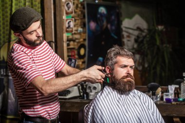Berber dükkanındaki sakallı adam. Berber dükkanında çalış. Erkek müşterinin saçını kesen kuaför. Berber dükkanında müşteriye hizmet eden kuaför. Berber dükkanında kuaförü ziyaret eden bir adam.