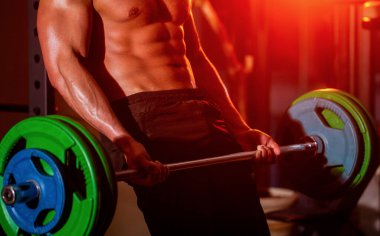 Sportif adam spor salonunda halteri kaldırıyor. Kapalı asansör halterleri egzersizi. Spor salonunda çalış. Altılı paketli atletik adam, mükemmel karın kasları var.