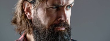 Erkeğin seksi görünüşü. Sakallı, bıyıklı hippi. Yakışıklı, vahşi erkek. Vahşi, yakışıklı, siyah sakallı bir erkeğin seksi yakın plan portresi. Acımasız sakallı adam portresi. Erkekliğin portresi