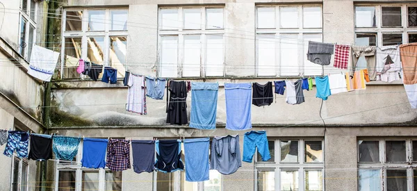 Laundry dryings on the rope. Washed clothes drying outside of an old house. Washed clothes drying. Fresh clean clothes are drying outside. Clothes hanging to dry on a clothes-line