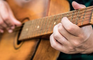 Akustik gitarlar çalıyor. Müzik konsepti. Gitar akustiği. Canlı müzik. Müzik festivali. Gitar çalan erkek müzisyen, müzik aleti. Akustik gitar çalan erkek elleri, yakın çekim.