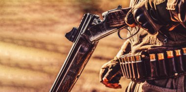 Avcı tüfeği ve sonbahar ormanında avlanmak için avlanma biçimi. Adam avda şu an. Sırt çantası ve av silahı olan bir avcı.