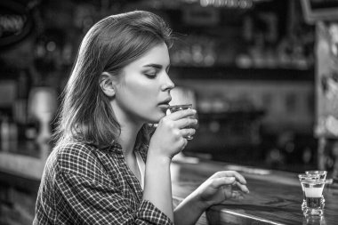 Depresyondaki kadın. İçki içen genç ve güzel bir kadın. Barda viski bardağı ya da alkol bağımlılığı ve alkol konsepti. Elinde bir bardak viski ya da rom tutan sarhoş kadın. Siyah ve beyaz