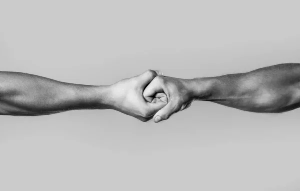 Male hand united in handshake. Man help hands, guardianship, protection. Two hands, isolated arm, helping hand of a friend. Friendly handshake, friends greeting. Rescue, helping hand. Black and white — Stock Photo, Image