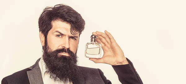 Perfume or cologne bottle and perfumery, cosmetics, scent cologne bottle, male holding cologne. Masculine perfume, bearded man in a suit. Male holding up bottle of perfume. Man perfume, fragrance
