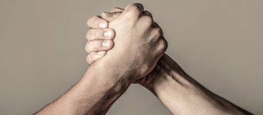 Bilek güreşi. Kapatıyoruz. Dostça tokalaşma, dostça selamlaşma, takım çalışması, arkadaşlık. El sıkışma, silah, arkadaşlık. El rekabeti güç karşılaştırmasına karşı. Erkek eli. İki adam bilek güreşi yapıyor.