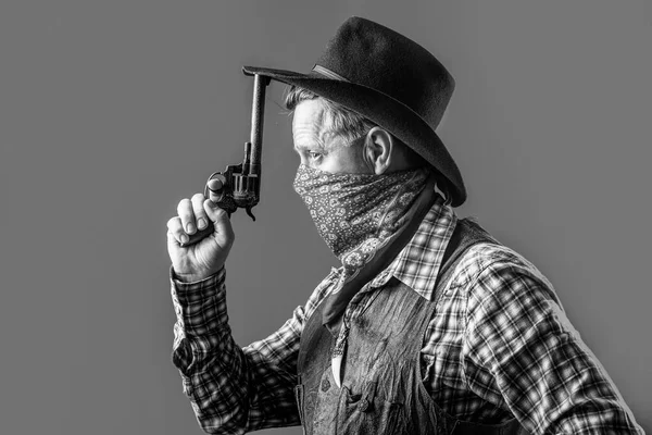 West, wapens. Portret van een cowboy. Amerikaanse bandiet met masker, westerse man met hoed. Portret van cowboy met hoed. Portret van een man met cowboyhoed, pistool. Portret van een cowboy. Zwart-wit — Stockfoto