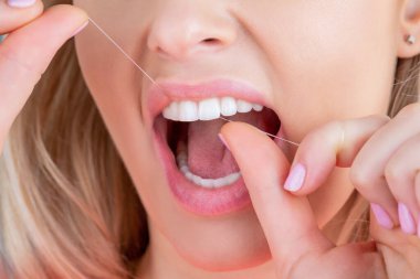 Diş ipi mi? Dişlerine bakıyorum. Sağlıklı diş kavramı. Diş ipi kullanmak. Ağız temizliği ve sağlık hizmetleri. Gülümseyen kadınlar diş ipi kullanır. Sağlıklı dişler. Diş ipi, diş ipi kullanan kadın.