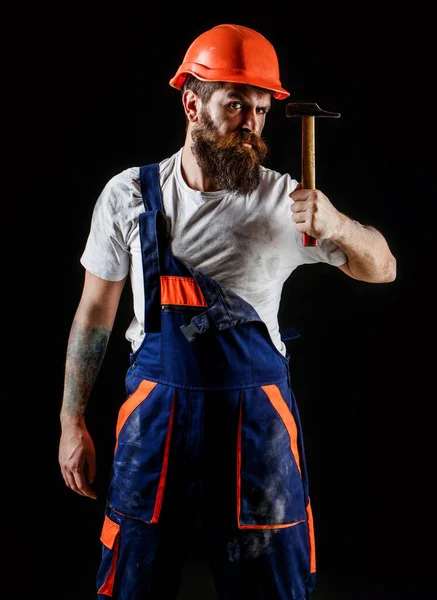 Een man met baard, helm, helm, hoed. Hamer hameren. Bouwer in helm, hamer, klusjesman, bouwers in hardhat — Stockfoto